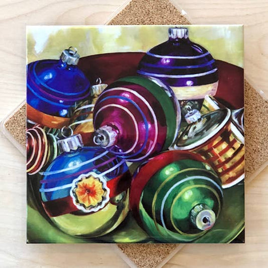 Trivet with a painting of colorful Christmas ornaments on a textured surface.