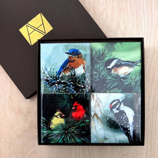 Set of four bird-themed coasters in a gift box on a wooden surface.