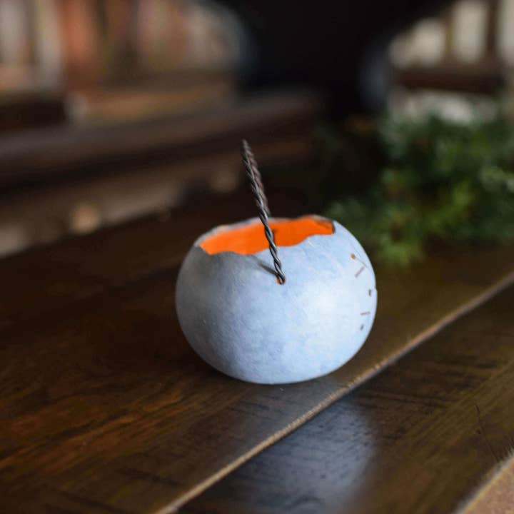 Decorative lantern with a lit candle inside on a wooden surface