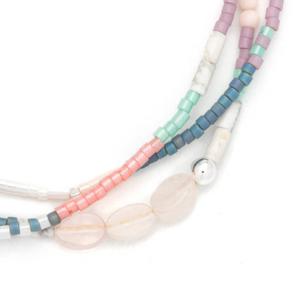 Colorful beaded bracelet strands on a white background