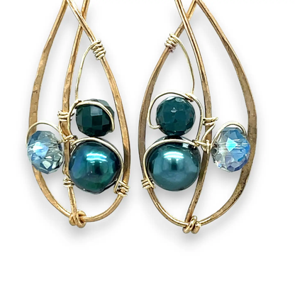 Pair of gold-framed earrings with blue and green beads on a white background