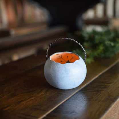 Decorative lantern with a lit candle inside on a wooden surface