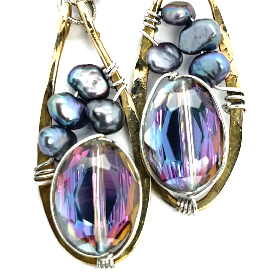 Earrings with purple teardrop-shaped gemstones and gold accents on a white background