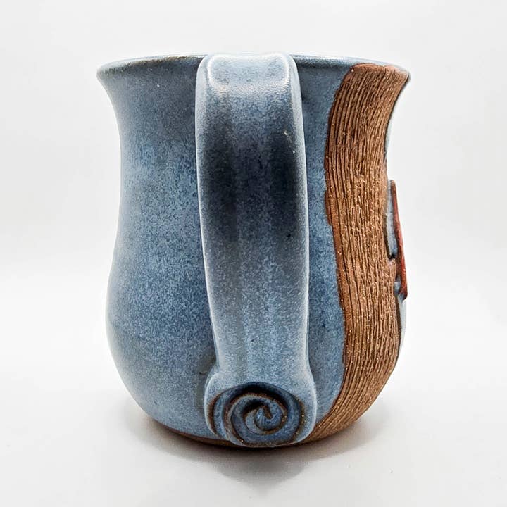 Ceramic mug with blue glaze and wooden accent on a white background