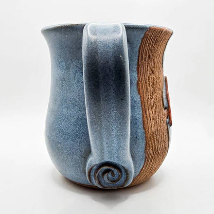 Ceramic mug with blue glaze and wooden accent on a white background