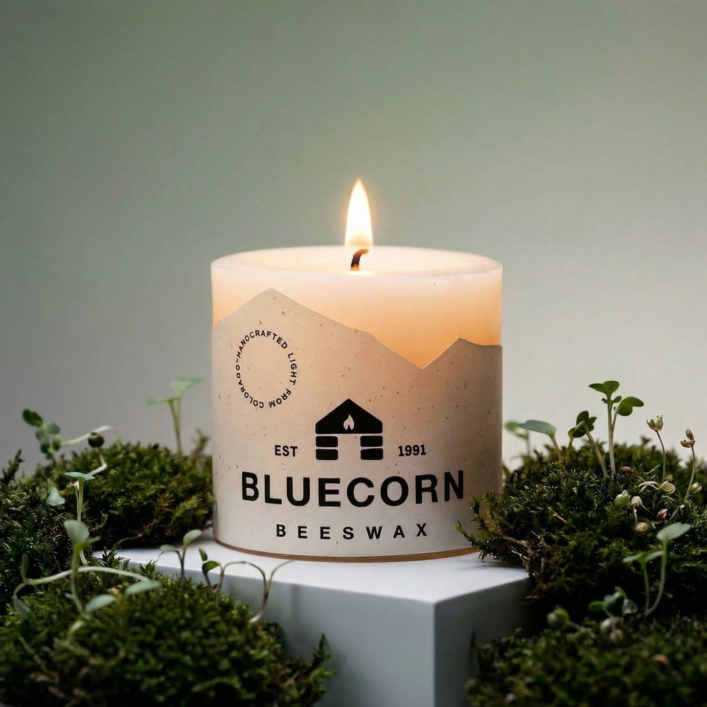 Bluecorn Beeswax white candle with a logo on a green background