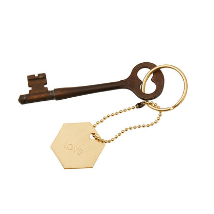 Vintage-style key with a gold tag labeled 'LOVE' on a white background