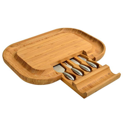 Wooden cheese board set with four silver cheese knives on a white background