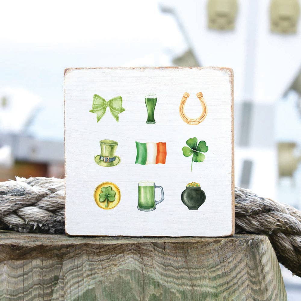 Decorative sign with St. Patrick's Day-themed icons on a wooden surface.
