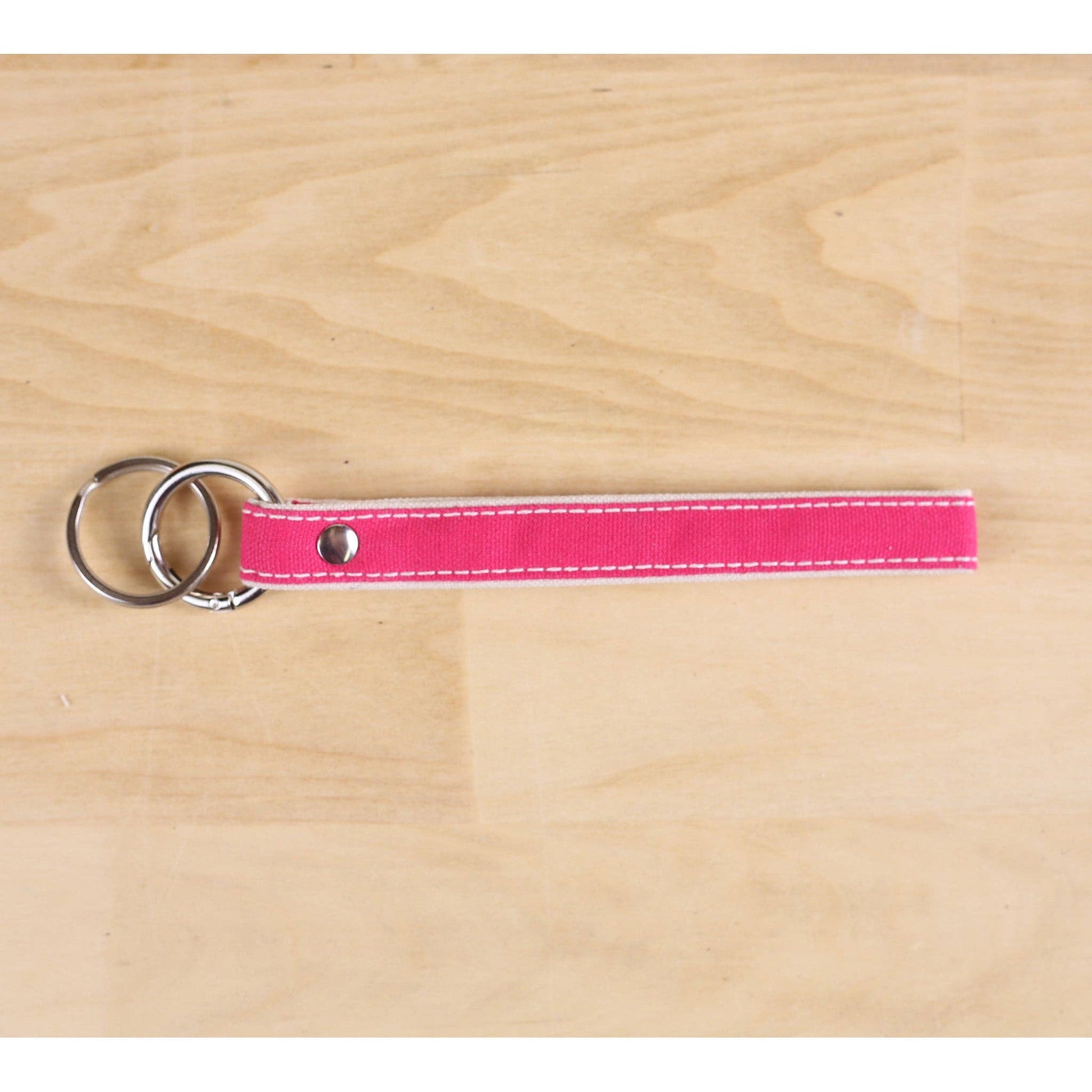 Pink keychain with metal rings on a wooden surface