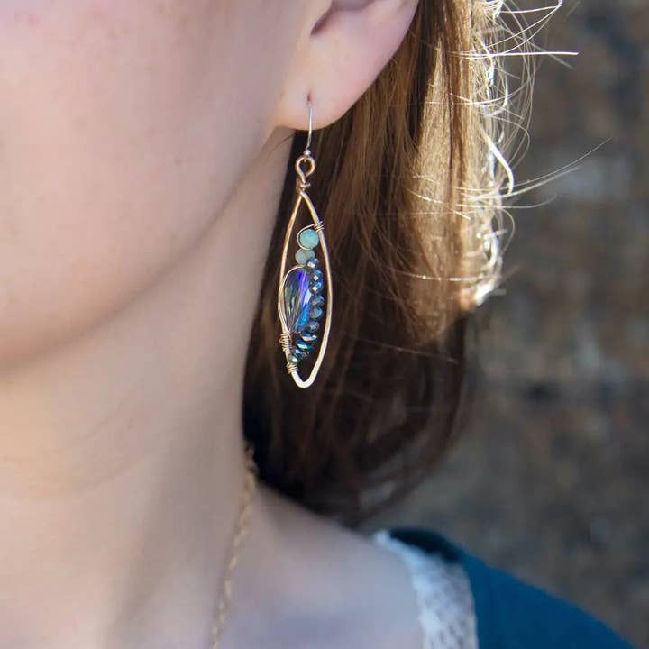 Close-up of a person wearing a decorative earring with a blurred background