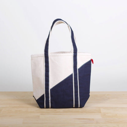 Tote bag with navy and beige design on a wooden surface