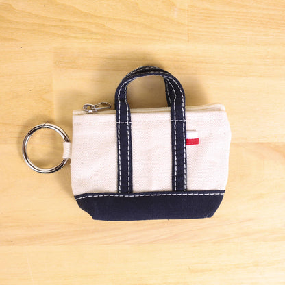 Small fabric bag with a keyring on a wooden surface
