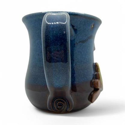 Blue ceramic mug with a handle on a white background