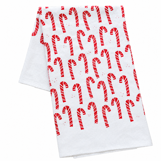 A cream colored tea towel with red candy cane design on a white background.