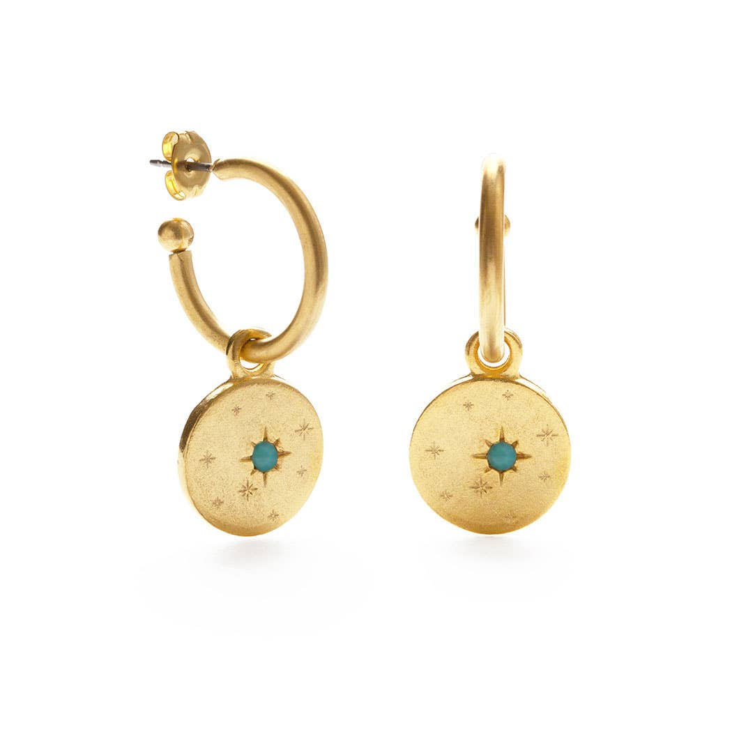 Gold hoop earrings with circular charms featuring a blue gemstone on a white background