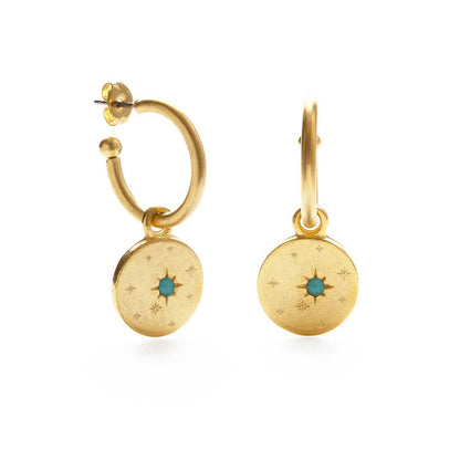 Gold hoop earrings with circular charms featuring a blue gemstone on a white background