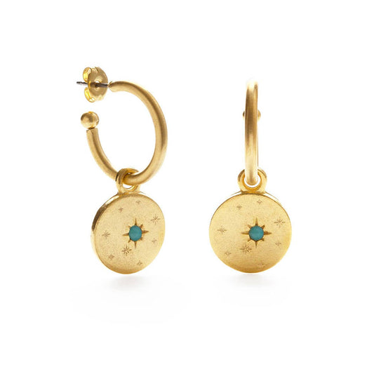 Gold hoop earrings with circular charms featuring a blue gemstone on a white background