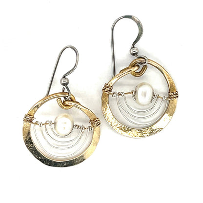 Pair of gold and silver circular earrings on a white background