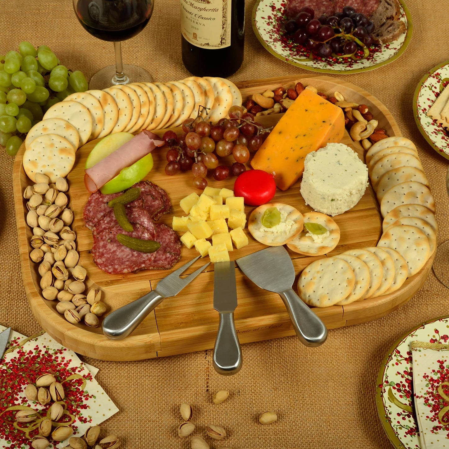 Wooden charcuterie board with assorted cheeses, meats, and crackers on a textured surface.