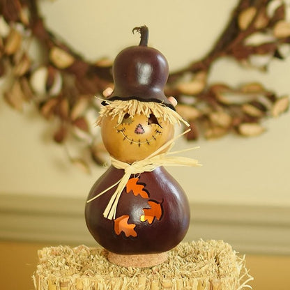 Decorative scarecrow gourd with a face on a hay bale with a blurred background