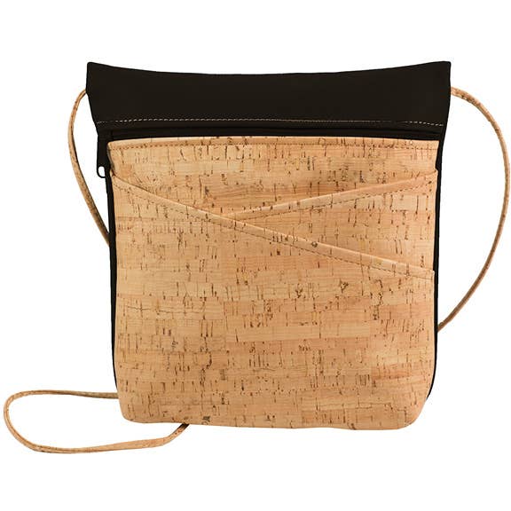 A black and cork cross body bag with an adjustable strap and two exterior crisscross pockets, displayed against a white background.