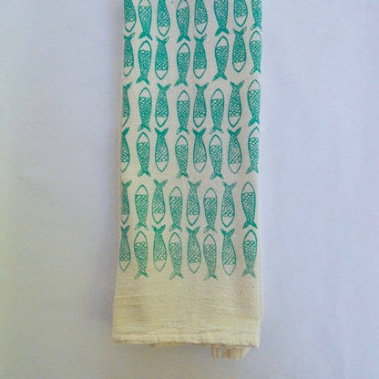 A natural cotton kitchen towel with turquoise fish printed designs