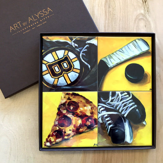 A set of four ceramic tile coasters with cork backing, displayed in a box with a 'Art by Alyssa' logo, featuring images inspired by Boston Bruins.