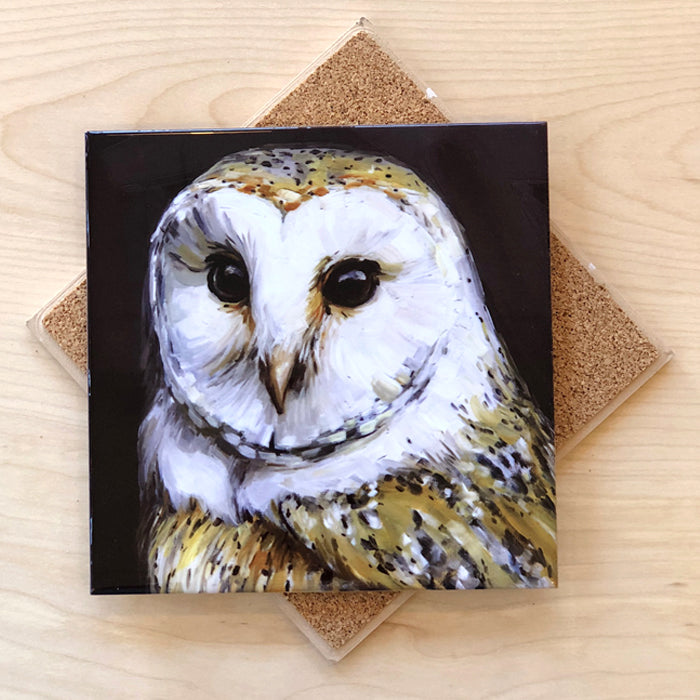 A square ceramic trivet with a cork backing, featuring a detailed painting of a barn owl in a dark background.