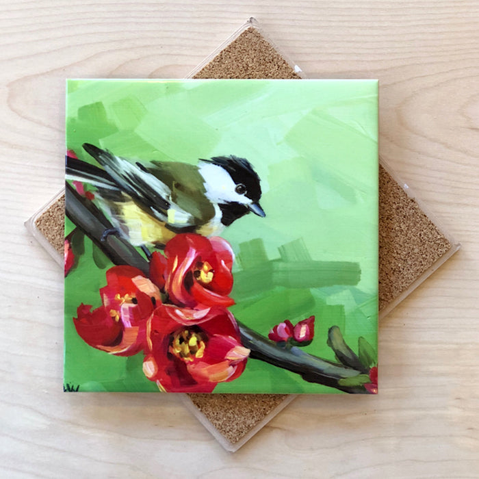 A square trivet with a cork backing, featuring a painted chickadee bird perched on a red flower branch. The trivet has a green background with a mix of red and yellow flowers.