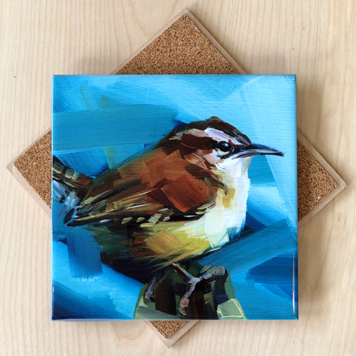 A square ceramic trivet with an image of a wren bird on a blue background, featuring cork backing.