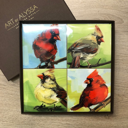 A set of four ceramic tile coasters with cork backing, each featuring a colorful oil painting of a bird, packaged in a gift box with 'Art by Alyssa' branding.